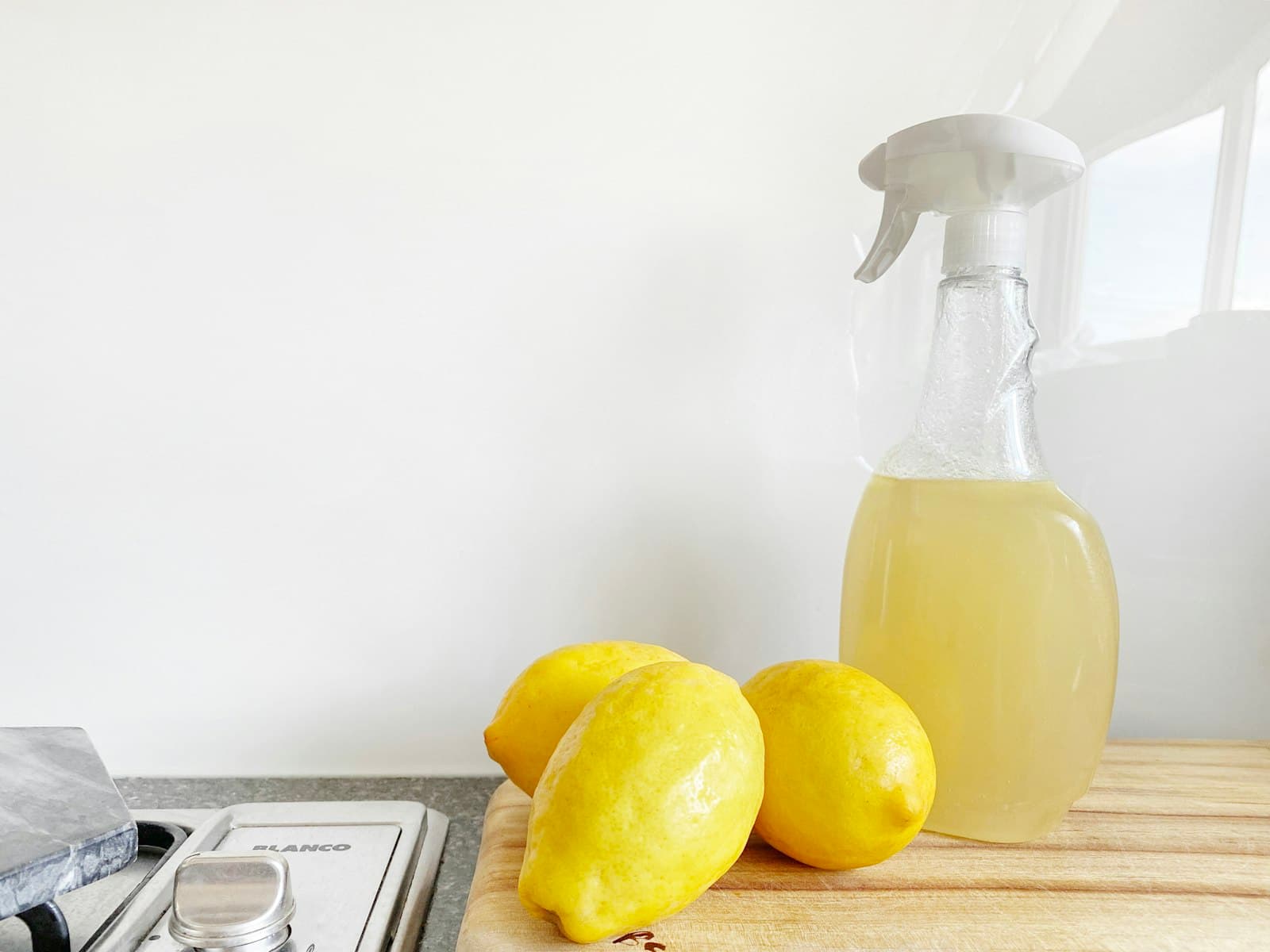 A lemon beside a glass bottle of vinegar